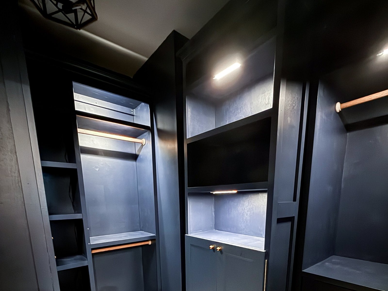 Moody blue custom closet with built-in storage, integrated lighting, and tailored design