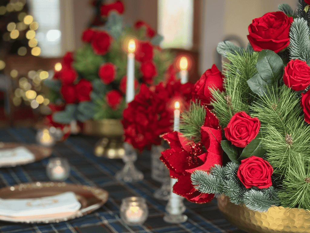 Luxury Christmas tablescape with red roses, evergreen arrangements, and candlelit dining details designed by Enchanted Journey Design